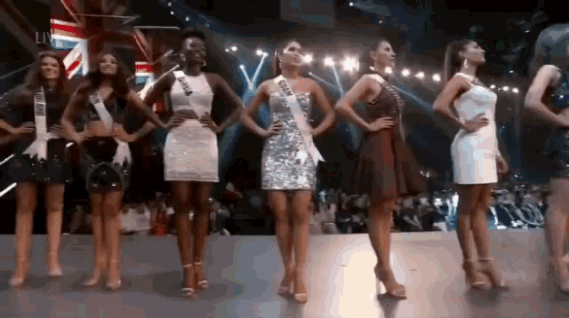 a group of women are standing on a stage with their hands on their hips and one has a sash that says cuba