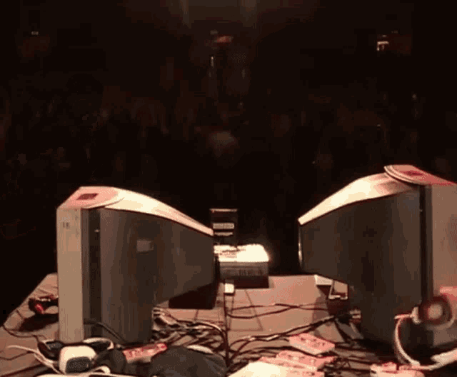 two computer monitors are on a table and one has a sticker on it that says ' x '