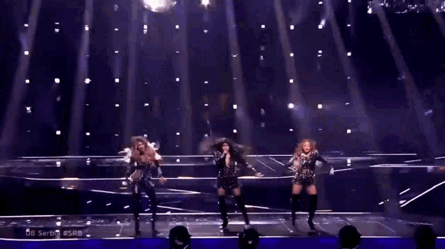 three women are dancing on a stage with the words serbia #srb written on the bottom
