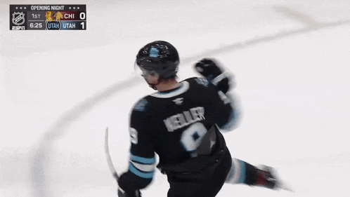 a hockey player in a utah jersey holds a stick