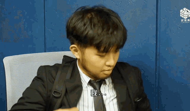 a man in a suit and tie with chinese writing on his shirt