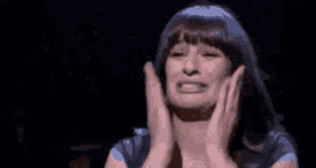a woman is praying with her hands folded in front of her chest .