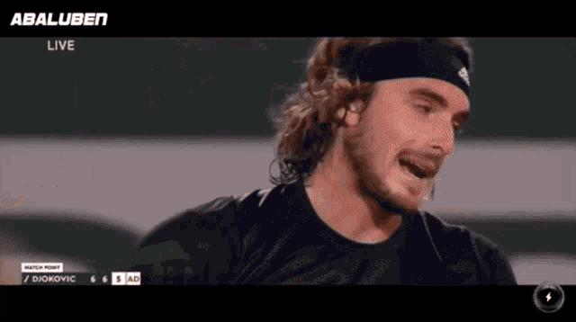 a man wearing a headband is smiling in front of a screen that says ' abaluben live '
