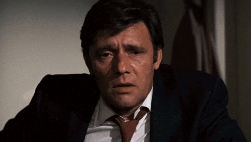a man in a suit and tie is looking down