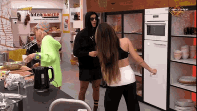 a group of people in a kitchen with a sign that says intermarche on it