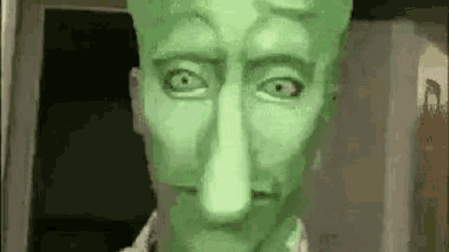 a close up of a green statue of a man with a long nose .