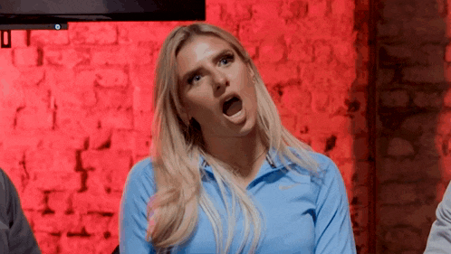a woman in a blue shirt is making a funny face .