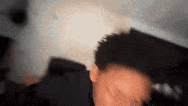 a blurry picture of a person 's face with a white wall behind them