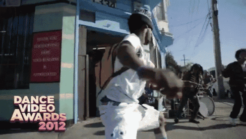 a man is dancing in front of a store that says dance video awards 2012