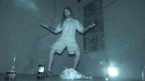 a man in a white shirt and shorts is kneeling down in front of a can of rapid-ev