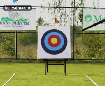 a target with a yellow center is on a field with a sign that says millet marvels