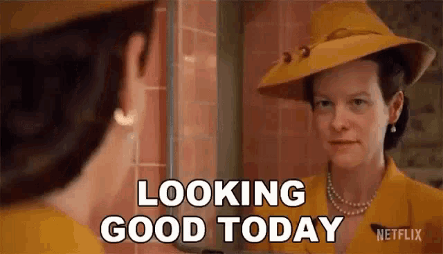 a woman in a yellow hat is looking at her reflection in a mirror and saying `` looking good today '' .