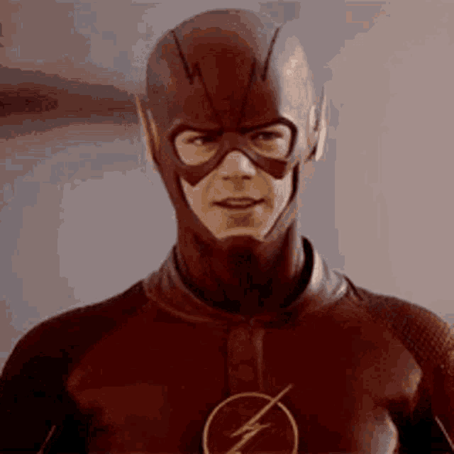 a man in a flash costume is looking at the camera .