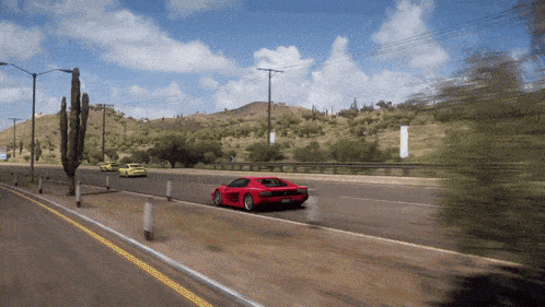 a red car is driving down a desert highway