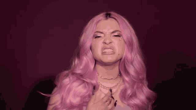 a girl with pink hair is making a funny face