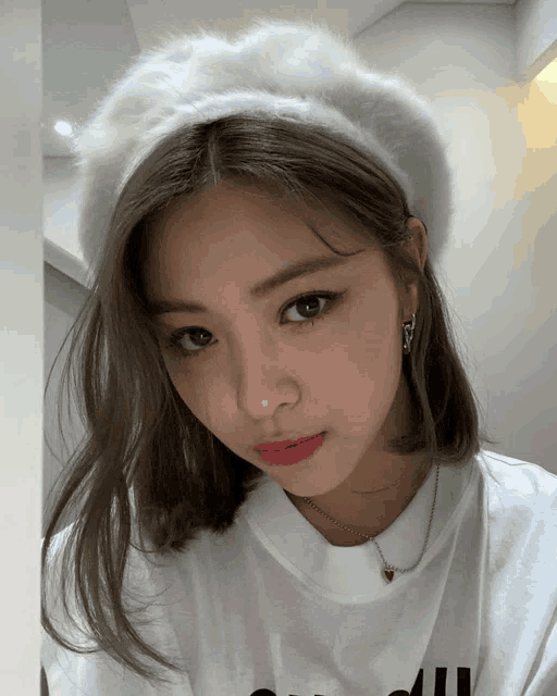 a woman wearing a white hat and a white t-shirt that says " seoul "