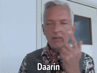 a man in a floral shirt says daarin in a sign language