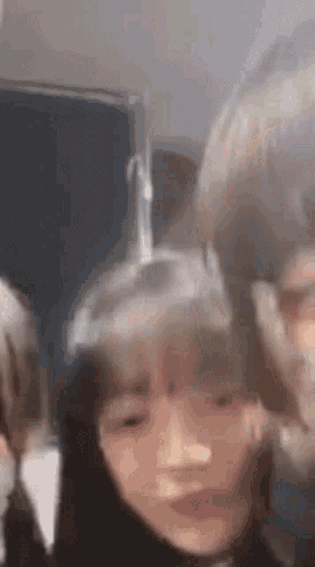 a group of people are standing next to each other in a room and making funny faces .