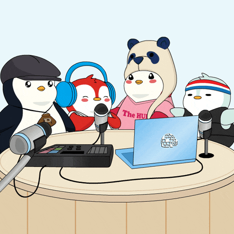 a group of penguins are sitting around a table with a laptop and microphone