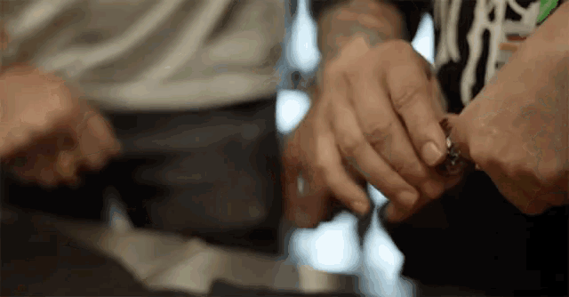 a close up of a person 's hands holding a ring .