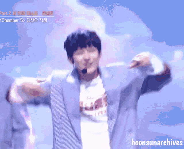 a man in a striped jacket is dancing in front of a blue sky with the words hoonsunarchives below him