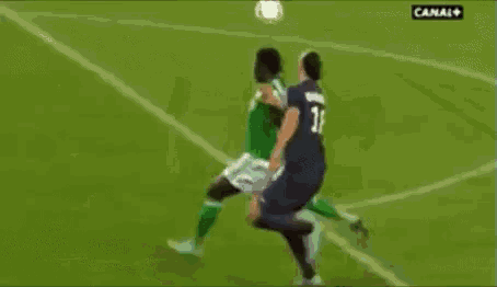 a soccer player wearing a fly emirates jersey kicks a soccer ball