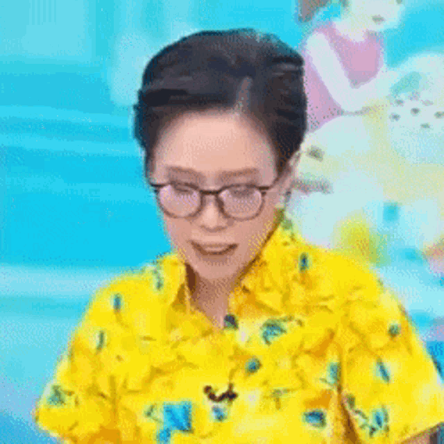 a woman wearing glasses and a yellow shirt