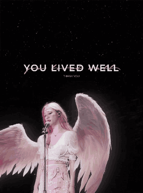 a woman with pink hair and angel wings singing into a microphone with the words you lived well thank you