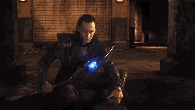 a man in a black jacket is holding a blue light in his hand .