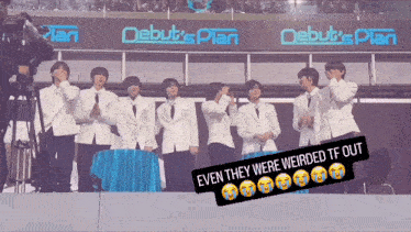 a group of men standing in front of a sign that says " debut 's plan "