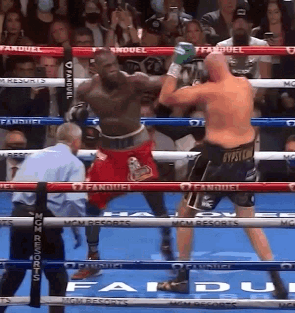 two boxers are fighting in a ring that says fanduel on the ropes