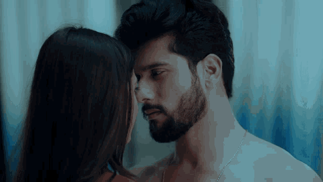 a man with a beard is kissing a woman with long hair
