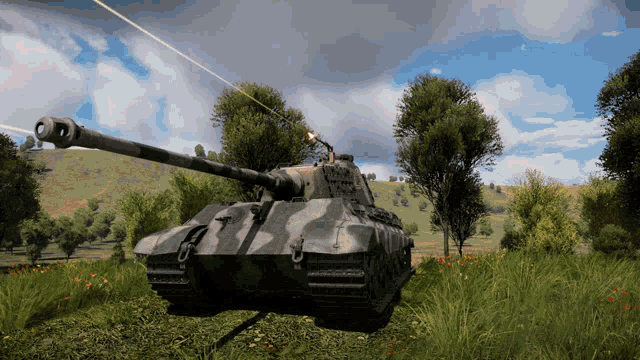 a camouflaged tank is parked in a field with trees in the background