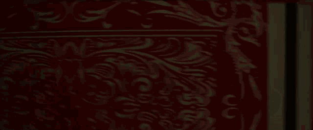 a person is standing in a dark room with a light on the wall .