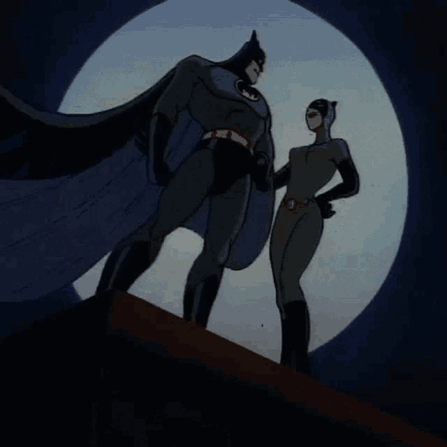 batman and catwoman standing next to each other in front of the moon