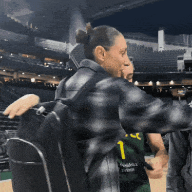 a woman wearing a providence swedish jersey is hugging another person