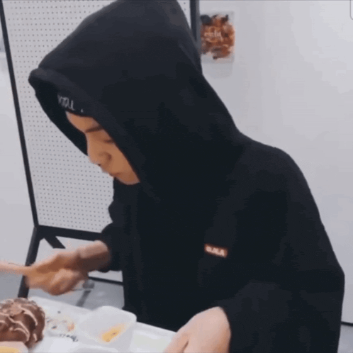 a man wearing a black hoodie and a headband that says seoul on it