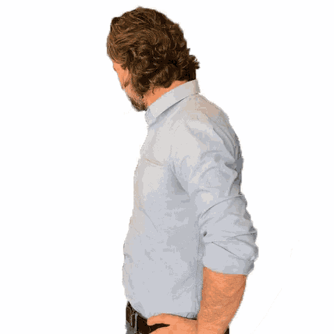 a man with a beard wearing a light blue shirt and a black belt