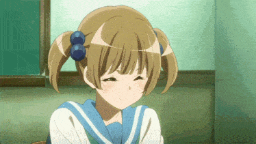 a girl with pigtails and blue bows in her hair is smiling