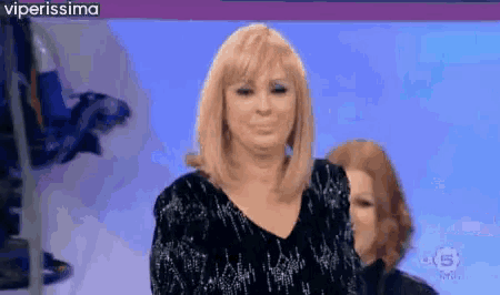a woman with blonde hair is smiling in front of a screen that says viperissima on it