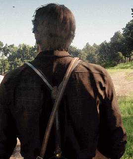 a man wearing suspenders and a plaid shirt is standing in a field