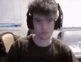 a man wearing headphones is looking at the camera .