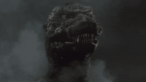 a close up of a monster 's head with its mouth open in the dark .