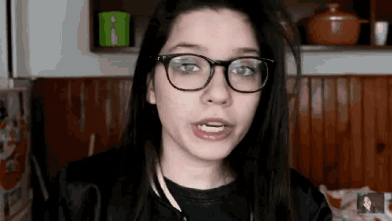 a young woman wearing glasses and a black jacket