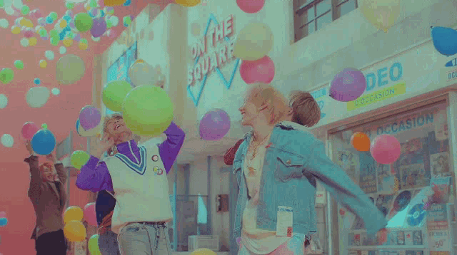 a group of people are playing with balloons and one of them has a shirt that says " i love you " on it