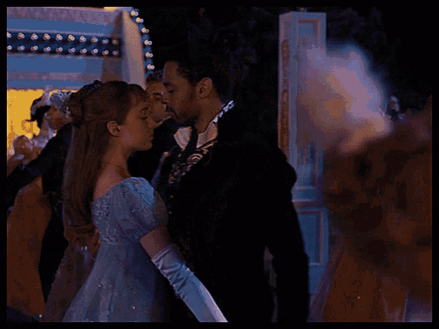 a man and a woman are kissing while dancing