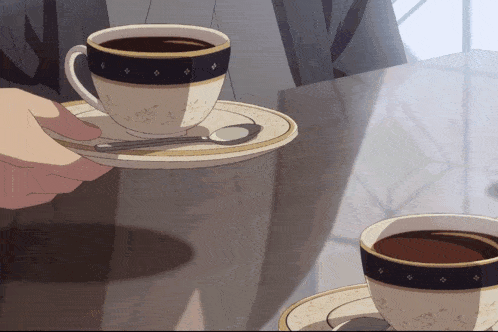 a person is holding a cup of coffee on a saucer
