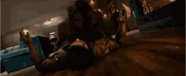 a man is laying on the floor with a woman standing behind him holding a gun