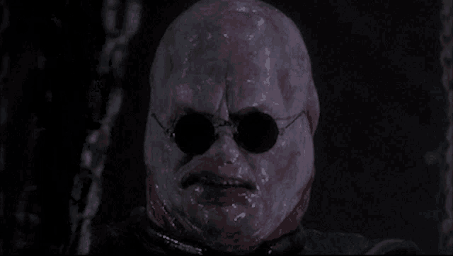 a close up of a person 's face with glasses on