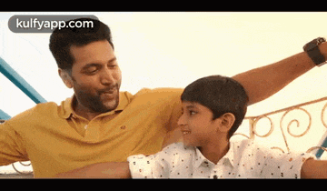 a man and a boy are sitting next to each other and smiling .